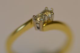 A small diamond two stone crossover ring in 18ct. Est. £90 - £100.