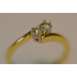 A small diamond two stone crossover ring in 18ct. Est. £90 - £100.