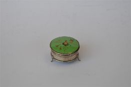 A green enamelled ring box on three feet decorated with a figure of a Dutch miller feeding