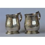 A good rare pair of baluster shaped half pint mugs on tapered pedestal feet and scroll decorated