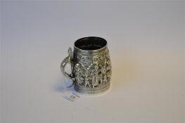 A good heavy Indian embossed mug profusely decorated with figures and flowers with lizard handle.