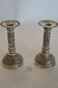 A good pair of Indian candlesticks with crimped rims with stems decorated with palm trees and