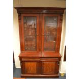 A mahogany glazed bookcase with moulded frieze on pedestal base with wavy fretwork. Est. £250 - £