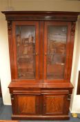 A mahogany glazed bookcase with moulded frieze on pedestal base with wavy fretwork. Est. £250 - £
