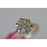 An attractive 18ct seven stone diamond cluster ring. Est. £130 - £140.