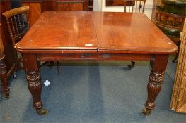 A mahogany 19th Century extending table with reeded supports and brass castors. Est. £100 - £120.