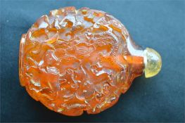 A carved amber scent bottle depicting numerous animals with lift off cover. Est. £150 - £200.