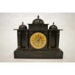 A heavy slate mantle clock with fluted columns. Est. £30 - £40.