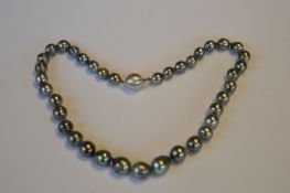 A string of graduated black pearl beads with 18ct diamond set ball clasp. Est. £400 - £450.