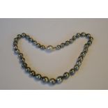 A string of graduated black pearl beads with 18ct diamond set ball clasp. Est. £400 - £450.