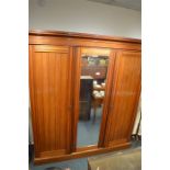 A good three door satinwood  triple wardrobe on pedestal base and moulded frieze. Est. £100 - £120.