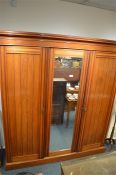 A good three door satinwood  triple wardrobe on pedestal base and moulded frieze. Est. £100 - £120.
