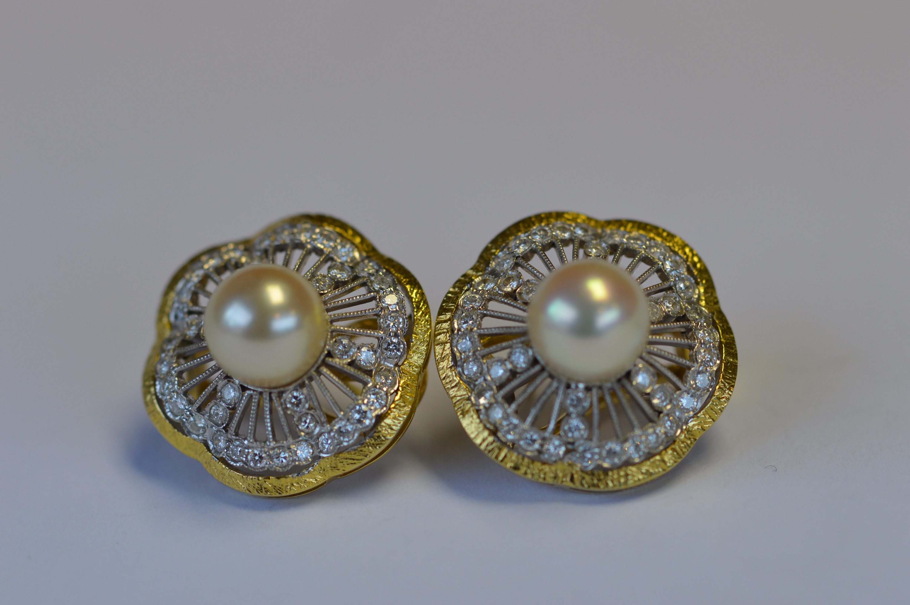 A heavy pair of 18ct two colour gold pearl and diamond ear studs. Est. £300 - £350.