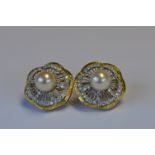 A heavy pair of 18ct two colour gold pearl and diamond ear studs. Est. £300 - £350.