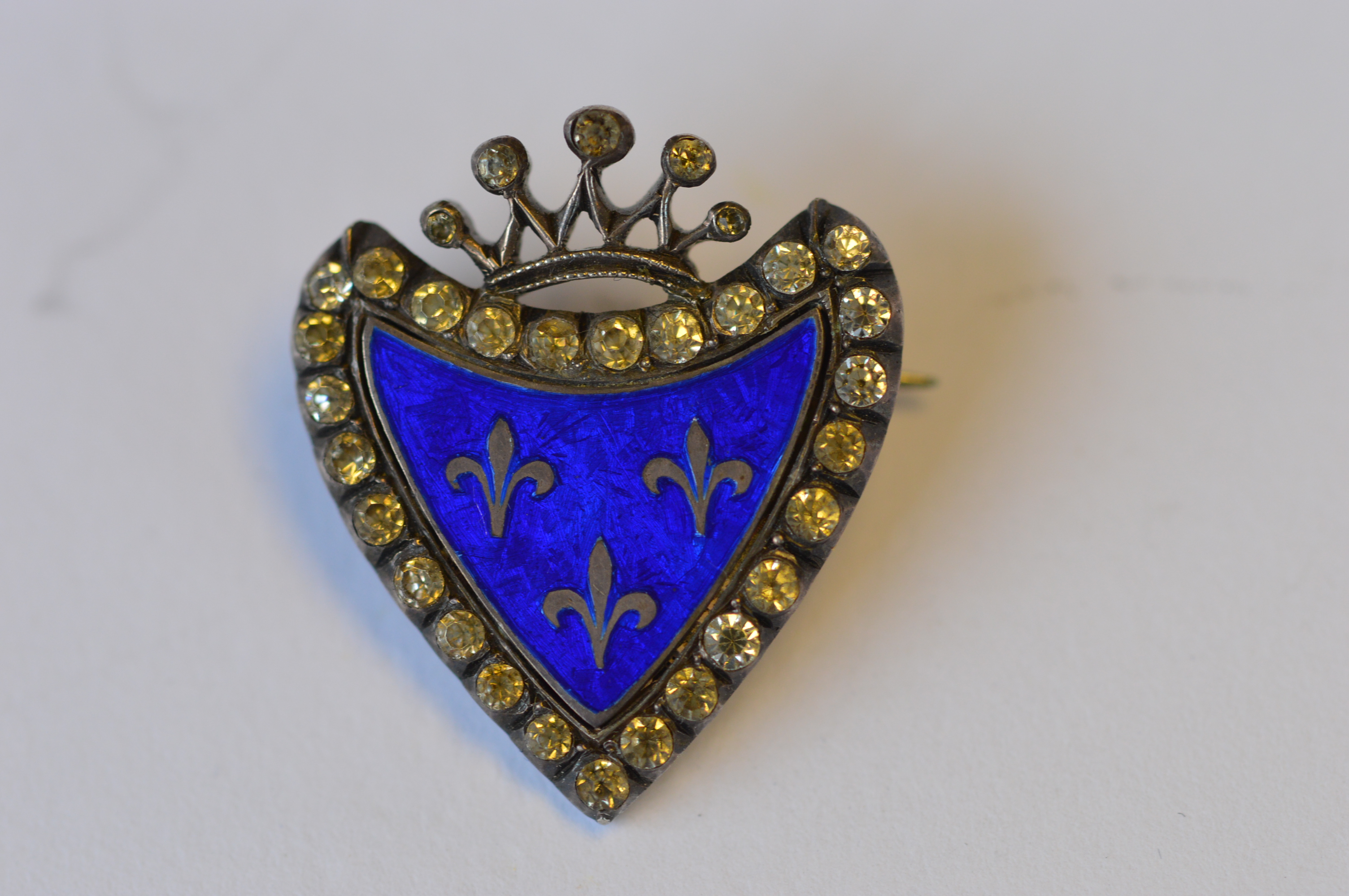 An attractive silver shield shaped brooch with paste border and enamelled centre. Est. £30 - £40.