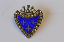 An attractive silver shield shaped brooch with paste border and enamelled centre. Est. £30 - £40.