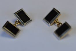 A heavy pair of platinum and gold cufflinks with onyx centres. Est. £150 - £200.