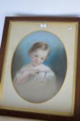 An oval pastel portrait of a child with gilt border in oak frame. 57cms x 43cms. Est. £40 - £50.