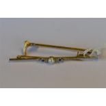 A small pearl and sapphire bar brooch in 9ct together with a riding crop gold brooch. Approx. 4.9
