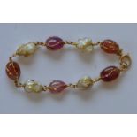 An Antique gold pearl and pink cabochon gem set bracelet. Est. £250 - £300.