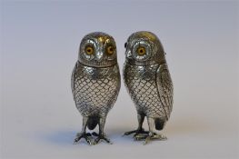 An attractive pair of Continental owls with textured feathered body standing on clawed feet with