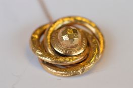 A circular gold twist target brooch set with safety chain. Approx 11 grams. Est. £80 - £90.