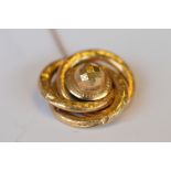A circular gold twist target brooch set with safety chain. Approx 11 grams. Est. £80 - £90.