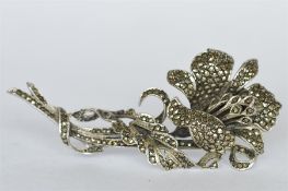 A silver and marcasite flower brooch. Est. £15 - £20.