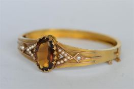 A pearl and citrine bangle with concealed clasp set in gold. Est. £380 - £420.