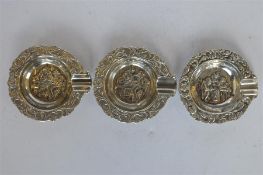 A group of three embossed ashtrays decorated with swirls and leaves. Approx. 55 grams. Est. £20 - £