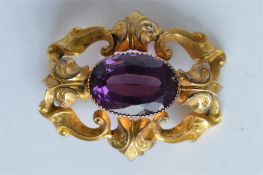 An attractive oval amethyst set brooch with scroll decoration. Est. £100 - £120.