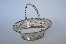 An attractive oval pierced Georgian swing handled basket with beaded rim and rope twist pedestal
