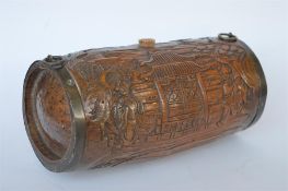 A cylindrical Chinese biscuit barrel carved with wooden scenes and brass mounts. Est. £25 - £30.