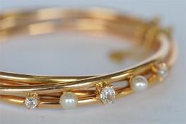 A good quality French diamond and pearl hinged bangle. Est. £500 - £550.