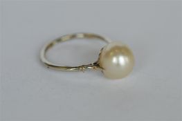 An attractive pearl single stone ring in fancy gold frame. Est. £280 - £320.