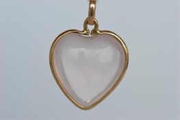 A gold mounted rose quartz heart shaped pendant. Est. £70 - £80.
