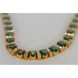 An attractive good quality emerald and diamond graduated necklace in boxed claw high carat gold