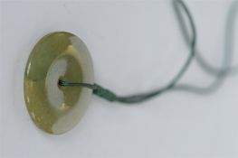 A modern jade pendant on velvet necklace. Est. £15 - £20.
