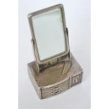 An unusual silver pepper pot in the form of a dressing table mirror with textured decoration.