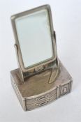 An unusual silver pepper pot in the form of a dressing table mirror with textured decoration.