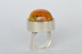 A large amber single stone ring in silver mount. Est. £30 - £40.