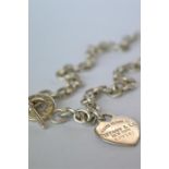 A good quality silver Tiffany necklace with heart shaped padlock and bar. Approx 63 grams. Est. £