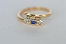 A clean sapphire and diamond three stone ring in rub-over mount set in gold. Est. £120 - £150.