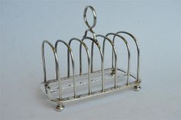 A good quality toast rack on ball feet and loop handle. London 1895. By Garrards. Est. £140 - £160.