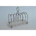 A good quality toast rack on ball feet and loop handle. London 1895. By Garrards. Est. £140 - £160.