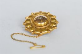 A circular gold target brooch with ball decoration. Est. £50 - £60.