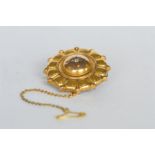 A circular gold target brooch with ball decoration. Est. £50 - £60.