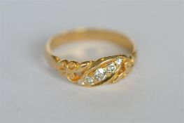 A small diamond five stone scroll decorated ring. Est. £150 - £200.