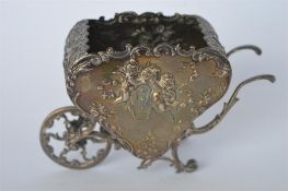 An unusual novelty holder in the form of a wheelbarrow, the body attractively decorated with cherubs