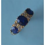 A sapphire and diamond seven stone carved half hoop ring in 18ct claw mount. Est. £250 - £300.